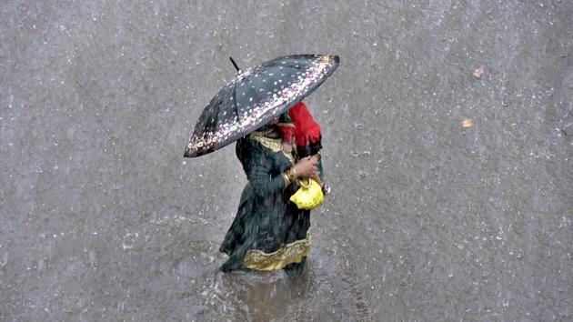 A woman carries a child on a waterlogged road during heavy rain, near ESI hospital, in Ludhiana, Punjab, on Thursday, August 01, 2019. Fairly widespread rainfall, with isolated “heavy to very heavy falls”, are likely over Punjab. (Photo by Gurpreet Singh / Hindustan Times) A woman carries a child on a waterlogged road during heavy rain, near ESI hospital, in Ludhiana, Punjab, on Thursday, August 01, 2019. Fairly widespread rainfall, with isolated “heavy to very heavy falls”, are likely over Punjab. (Photo by Gurpreet Singh / Hindustan Times)