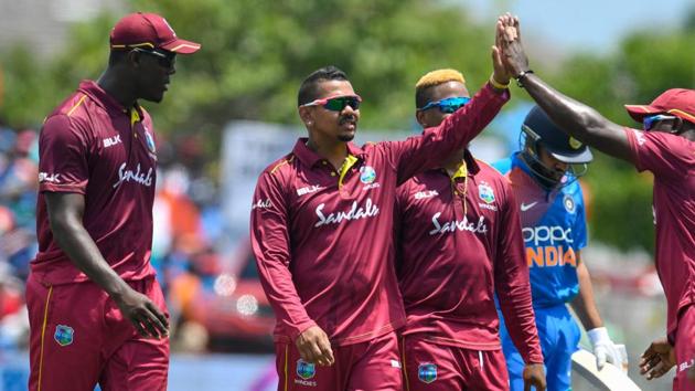 Carlos Brathwaite (L) watch as Sunil Narine (2L) of West Indies celebrates the dismissal of Rohit Sharma(AFP)