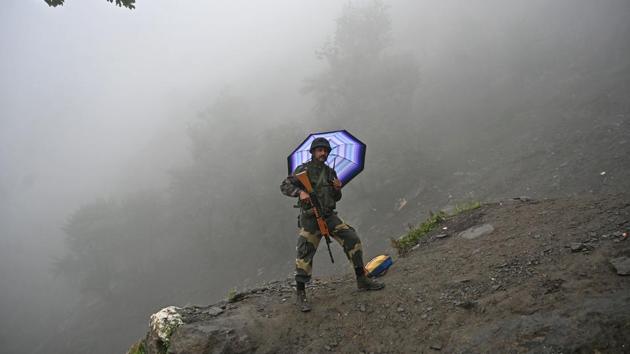 An Indian Border Security Force (BSF) soldier stands guard during heavy rainfall at the PishuTop, some 127 km southeast of Srinagar during the annual Hindu pilgrimage to the holy cave shrine of Amarnath. Every year, thousands of pilgrims trek through treacherous mountains in Kashmir, along icy streams, glacier-fed lakes and frozen passes, to reach the Amarnath cave, located at an altitude of 3880 m (12,729 feet), where a Shiva Lingam, stands for worship. (Tauseef Mustafa / AFP) An Indian Border Security Force (BSF) soldier stands guard during heavy rainfall at the PishuTop, some 127 km southeast of Srinagar during the annual Hindu pilgrimage to the holy cave shrine of Amarnath. Every year, thousands of pilgrims trek through treacherous mountains in Kashmir, along icy streams, glacier-fed lakes and frozen passes, to reach the Amarnath cave, located at an altitude of 3880 m (12,729 feet), where a Shiva Lingam, stands for worship. (Tauseef Mustafa / AFP)