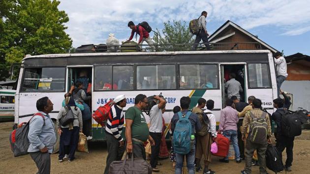 Tourists walk towards a bus at the Tourist Reception Center after an advisory indicating danger to Amarnath Yatris and visitors in the Kashmir Valley was released on August 02. Speculations over the motive behind the advisory ran rife with no clear explanations coming forward. (Waseem Andrabi / HT Photo)