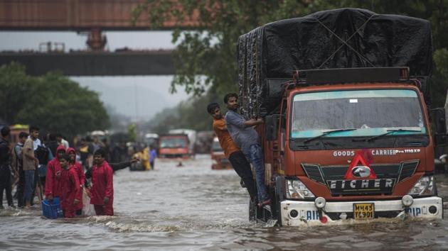 Mumbai, India - Aug. 4, 2019: People walk from flooded road as there is water logging due to heavy rain on LBS Road near Sion station in Mumbai.(Pratik Chorge/HT Photo)