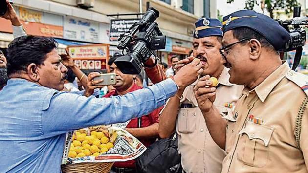 Shiv Sena workers offer sweets to policemen as they celebrate the effective revoking of Article 370 in Mumbai. (Kunal Patil/HT Photo) Shiv Sena workers offer sweets to policemen as they celebrate the effective revoking of Article 370 in Mumbai. (Kunal Patil/HT Photo)