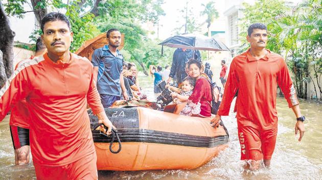 NDRF team rescues residents of Prathamesh Park, Baner in Pune on Monday using lifeboat.(MILIND SAURKAR/HT)