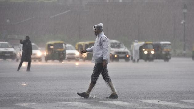 Delhi Traffic police personnel seen working during heavy rain at Vijay Chowk. Slow-down in traffic movement was reported from several areas around Sri Aurobindo Marg and Africa Avenue in South Delhi, Patparganj, Laxmi Nagar and Pandav Nagar among busy East Delhi localities and ITO and Kashmere Gate among busy Central Delhi traffic intersections, Delhi Traffic Police officials said. (Sanjeev Verma / HT Photo) 