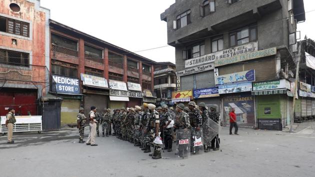 A police officer briefs his men at a deserted street during curfew in central Srinagar, Jammu and Kashmir. After the government revoked Kashmir’s special status with a presidential order on Monday, thousands of newly deployed troops arrived and internet and phone services remained cut in the restive Himalayan region. (AP) A police officer briefs his men at a deserted street during curfew in central Srinagar, Jammu and Kashmir. After the government revoked Kashmir’s special status with a presidential order on Monday, thousands of newly deployed troops arrived and internet and phone services remained cut in the restive Himalayan region. (AP)