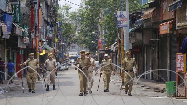 Policemen patrol a street during restrictions, at Raghunath Bazar in Jammu, Monday. Restrictions and night curfews were imposed in several districts of Jammu and Kashmir as the Valley remained on edge with authorities stepping up security deployment. (Photo: PTI) Policemen patrol a street during restrictions, at Raghunath Bazar in Jammu, Monday. Restrictions and night curfews were imposed in several districts of Jammu and Kashmir as the Valley remained on edge with authorities stepping up security deployment. (Photo: PTI)