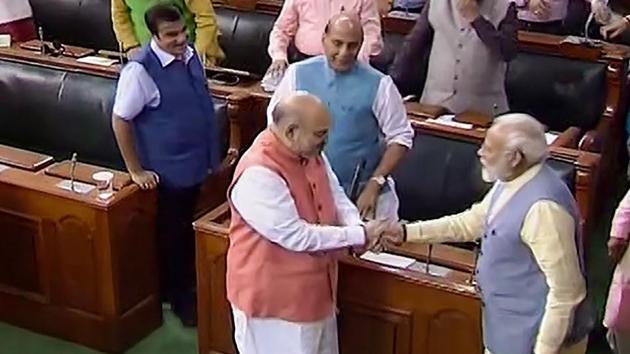 Prime Minister Narendra Modi shakes hands with Union Home Minister Amit Shah after Parliament approved the abrogation of special status given to J&K under Article 370, in the Lok Sabha, in New Delhi, Tuesday, Aug 6, 2019.(PTI)