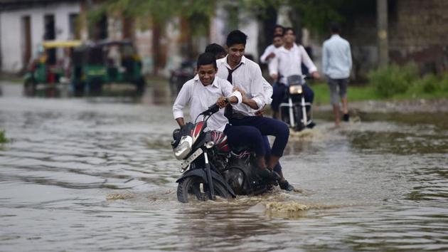 School boys ride a motorcycle through a waterlogged road after heavy rain at Dhanauri in Greater Noida, on Tuesday, August 6, 2019.(Virendra Singh Gosain/HT PHOTO) School boys ride a motorcycle through a waterlogged road after heavy rain at Dhanauri in Greater Noida, on Tuesday, August 6, 2019.(Virendra Singh Gosain/HT PHOTO)