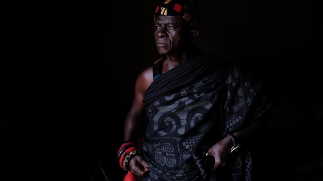 Nana Assenso, 68, chief of Adidwan, a village in Ghana’s interior, looks on before visiting the grave of his uncle Kwame Badu. His uncle’s name Kwame Badu, has been passed on through the family in remembrance of an ancestor with that name who was captured and sold into slavery long ago. “Growing up, I was told the story of two of my great-great-grand-uncles Kwame Badu and Kofi Aboagye who were captured and sold into slavery,” said Assenso. (Francis Kokoroko / REUTERS) Nana Assenso, 68, chief of Adidwan, a village in Ghana’s interior, looks on before visiting the grave of his uncle Kwame Badu. His uncle’s name Kwame Badu, has been passed on through the family in remembrance of an ancestor with that name who was captured and sold into slavery long ago. “Growing up, I was told the story of two of my great-great-grand-uncles Kwame Badu and Kofi Aboagye who were captured and sold into slavery,” said Assenso. (Francis Kokoroko / REUTERS)
