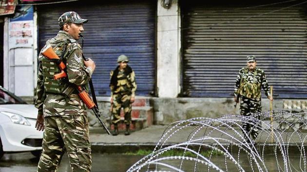 Security forces stand guard next to barbed wire laid across a road during restrictions after the Centre effectively scrapped special status for Jammu and Kashmir on Wednesday.(Reuters image)