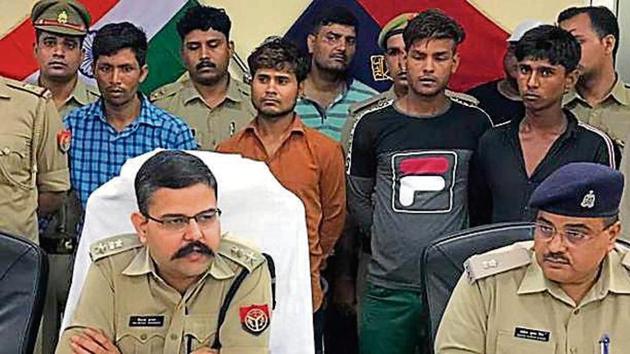 Gautam Budh Nagar SSP Vaibhav Krishna (left) with the four arrested men (second row). (Sourced) Gautam Budh Nagar SSP Vaibhav Krishna (left) with the four arrested men (second row). (Sourced)