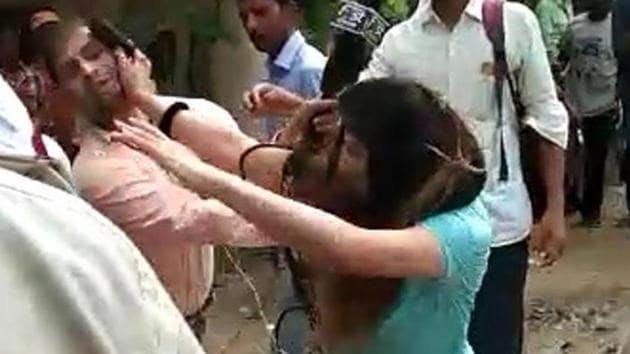 The woman, spotting a journalist making a video of the incident, snatched his camera and started assaulting him.(Sourced)