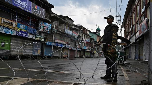 Security personnel stands guard on a street during a curfew in Srinagar on Thursday.(AFP File)