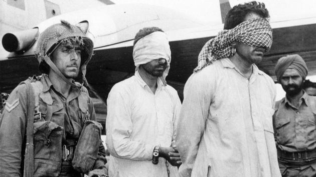 In this Aug. 12, 1965, file photo, two blindfolded and chained men, identified as Pakistani officers, are led away by an Indian soldier after they were captured during fighting in Kashmir. In Sept. 1965 India and Pakistan agreed to U.N.-mandated cease-fire, ending a stalemated war.(AP file photo)