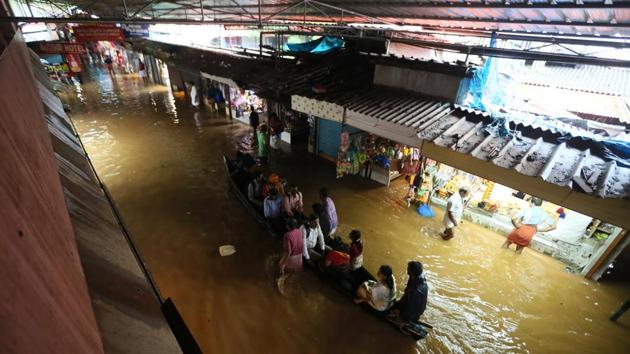 People ride on boats at Parassinikadavu Muthappan temple, in Kannur district. Of the 44 rivers in the state more than half are in spate and many dams are filled to the brim. More than 20,000 people have been evacuated to safer places as overflowing rivers and swollen dams flooded several districts amid heavy rains. (HT Photo)