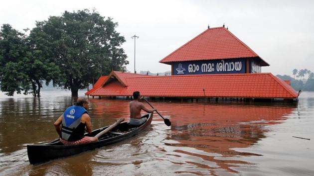 Members of a rescue team row a boat towards a submerged temple to look for stranded people on the outskirts of Kochi in Kerala.(Reuters Photo)