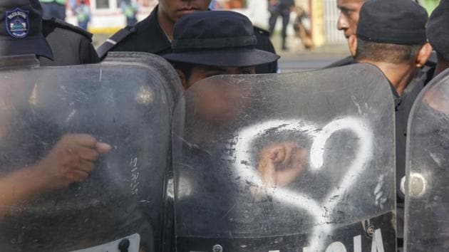 Nicaraguan riot police set up a shield wall as a group of doctors, nurses and medical students protest against the government of President Daniel Ortega, in Managua, Nicaragua. The Central American nation has been in crisis since April 2018, when protests erupted demanding Ortega's exit from office and early elections, with demonstrators accusing him of consolidating power and ruling in an authoritarian manner. (Alfredo Zuniga / AP)