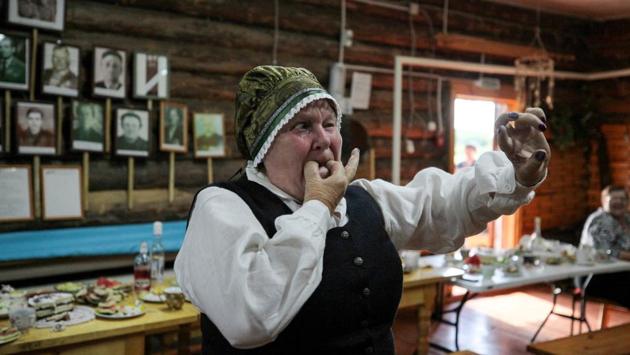 A villager wearing a traditional Latvian dress whistles during a reception at a village club in Bobrovka, some 350 km of Omsk. The people of the remote Siberian village Bobrovka call it the “Little Latvia of the Taiga,” where Baltic traditions continue more than 100 years after settlers from the region first arrived. (Alexei Malgavko / AFP) A villager wearing a traditional Latvian dress whistles during a reception at a village club in Bobrovka, some 350 km of Omsk. The people of the remote Siberian village Bobrovka call it the “Little Latvia of the Taiga,” where Baltic traditions continue more than 100 years after settlers from the region first arrived. (Alexei Malgavko / AFP)