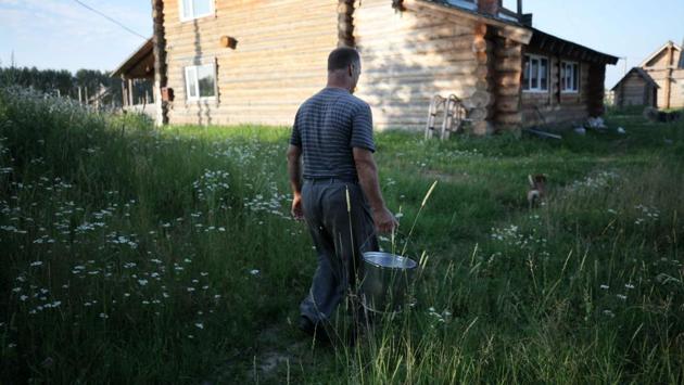 Villager Sergei Benke carries a bucket with milk in the village. Today, many of the roughly 130 villagers still speak Latvian, though Russian is the language of day-to-day-life. (Alexei Malgavko / AFP) Villager Sergei Benke carries a bucket with milk in the village. Today, many of the roughly 130 villagers still speak Latvian, though Russian is the language of day-to-day-life. (Alexei Malgavko / AFP)