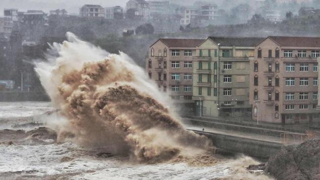 Waves hit a sea wall in front of buildings in Taizhou, China's eastern Zhejiang province. China issued a red alert for incoming Super Typhoon Lekima which is expected to batter eastern Zhejiang province early today with high winds and torrential rainfall. (AFP / China OUT)