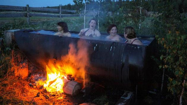 Latvian women bath in a huge tub heated by a bonfire. Almost every family owns the traditional Latvian dress, which they bring out for special occasions when songs and dances from the homeland are also performed. (Alexei Malgavko / AFP) Latvian women bath in a huge tub heated by a bonfire. Almost every family owns the traditional Latvian dress, which they bring out for special occasions when songs and dances from the homeland are also performed. (Alexei Malgavko / AFP)