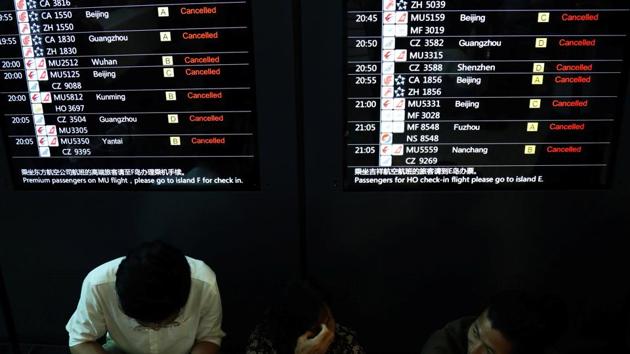 People sit before an information screen showing flights cancelled in anticipation of Typhoon Lekima at the Shanghai Hongqiao International Airport. More heavy rain was forecast for the Shanghai area and the neighbouring provinces of Anhui, Jiangsu and Zhejiang, with authorities warning of possible flash floods, mudslides and landslides caused by the downpours. (Tang Yanjun / CNS via REUTERS)