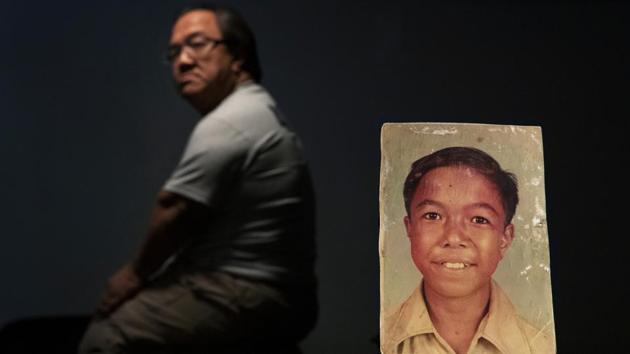 A sexual abuse survivor who would only go by the initials C.M.V., 58, sits behind a photo of himself when he was about 11 years old. C.M.V. says in a lawsuit he was sexually molested between the ages of 9 and 13 by Monsignor Jose Ada Leon Guerrero, a priest at the time at Nino Perdido y Sagrada Familia Catholic Church where C.M.V. served as an altar boy. “I try not to think about it,” said C.M.V. (David Goldman / AP) A sexual abuse survivor who would only go by the initials C.M.V., 58, sits behind a photo of himself when he was about 11 years old. C.M.V. says in a lawsuit he was sexually molested between the ages of 9 and 13 by Monsignor Jose Ada Leon Guerrero, a priest at the time at Nino Perdido y Sagrada Familia Catholic Church where C.M.V. served as an altar boy. “I try not to think about it,” said C.M.V. (David Goldman / AP)