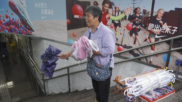 A woman sells umbrella at a subway entrance as Typhoon Lekima approaches in Shanghai. Shanghai Disneyland was also closed for the first time since the amusement park opened in 2016. (Erika Kinetz / AP)