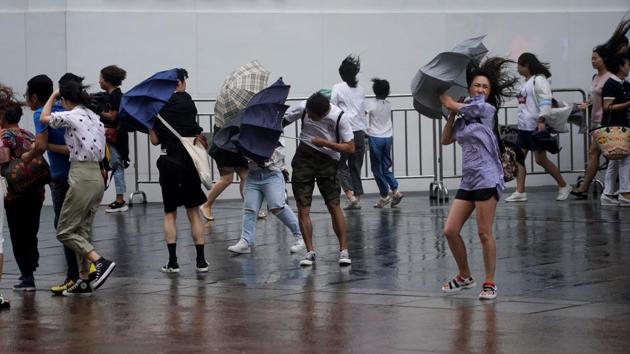 People walk in the rainstorm as Typhoon Lekima approaches in Shanghai. Waves several metres high hit the coastline as the storm made landfall in Zhejiang province, south of Shanghai. (Aly Song / REUTERS)