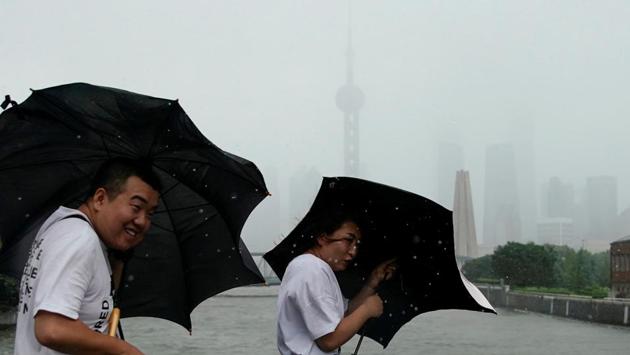 People walk in the rainstorm in Shanghai. China issued a red alert as the storm approached on Friday, before downgrading the level to orange as winds eased on Saturday morning. Lekima has been downgraded from a super typhoon to a typhoon as it headed northwards inland. (Aly Song / REUTERS)