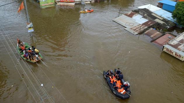 Navy personnel evacuate flood-affected people to safer places in Sangli district. (REUTERS) Navy personnel evacuate flood-affected people to safer places in Sangli district. (REUTERS)