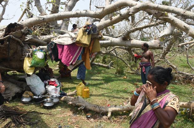 A tribal family seen under a collapsed tree that was hit by cyclone Fani, at Birapratap Pur Village, Odisha.(Photo by Arabinda Mahapatra / Hindustan Times)