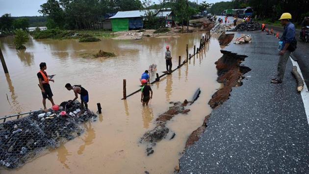 Workers repair a portion of a damaged road as floodwaters submerged areas of Ye township in Mon State. Hundreds of soldiers, firefighters and local rescue workers were still pulling bodies and vehicles out of the muddy wreckage of Paung township on Sunday. “The latest death toll we have from the landslide in Mon state was 52,” Brigadier General Zaw Min Tun said. (Sai Aung Main / AFP) Workers repair a portion of a damaged road as floodwaters submerged areas of Ye township in Mon State. Hundreds of soldiers, firefighters and local rescue workers were still pulling bodies and vehicles out of the muddy wreckage of Paung township on Sunday. “The latest death toll we have from the landslide in Mon state was 52,” Brigadier General Zaw Min Tun said. (Sai Aung Main / AFP)