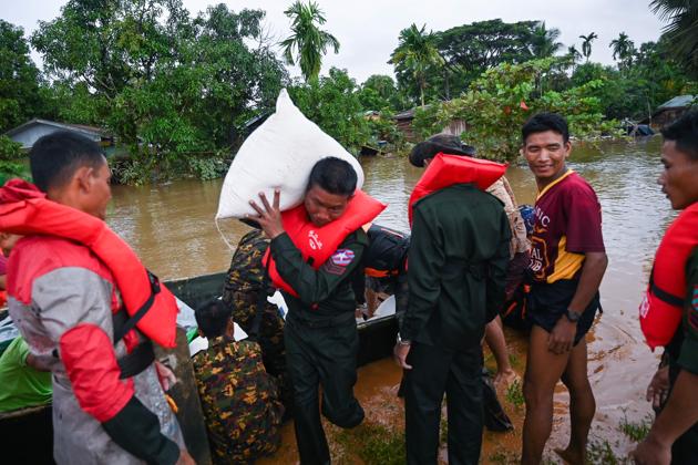 Army soldiers unload a sack from a boat. As the rainy season reaches its peak, the country’s armed forces are pitching in and have readied helicopters to deliver supplies. (Sai Aung Main / AFP) Army soldiers unload a sack from a boat. As the rainy season reaches its peak, the country’s armed forces are pitching in and have readied helicopters to deliver supplies. (Sai Aung Main / AFP)