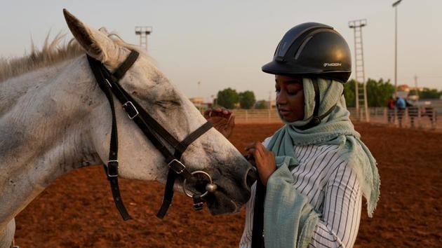Einas, 18, touches the horse she rides at a riding class, at the Equestrian Club, in Khartoum. Einas has been riding for a year and her father is a race horse rider. "If your family members are interested, it's easier than if you start on your own," Einas said about being a female horse rider. (Andreea Campeanu / REUTERS) Einas, 18, touches the horse she rides at a riding class, at the Equestrian Club, in Khartoum. Einas has been riding for a year and her father is a race horse rider. "If your family members are interested, it's easier than if you start on your own," Einas said about being a female horse rider. (Andreea Campeanu / REUTERS)