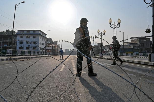 Paramilitary troopers stand guard behind a barbed fence wire as they block a road during a curfew in Srinagar. The Union Government moved a resolution in Rajya Sabha to scrap Article 370 of the Constitution that gives special status to Jammu and Kashmir. He also added that revocation of Article 370 will kickstart the development of Kashmir. (TAUSEEF MUSTAFA / AFP) Paramilitary troopers stand guard behind a barbed fence wire as they block a road during a curfew in Srinagar. The Union Government moved a resolution in Rajya Sabha to scrap Article 370 of the Constitution that gives special status to Jammu and Kashmir. He also added that revocation of Article 370 will kickstart the development of Kashmir. (TAUSEEF MUSTAFA / AFP)