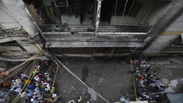 People gathered around the location of a fire that broke out in a multi-storey building in Okhla’s Zakir Nagar in the early hours of the day, in New Delhi. At least six people died and 10 were injured. (Burhaan Kinu / HT Photo) People gathered around the location of a fire that broke out in a multi-storey building in Okhla’s Zakir Nagar in the early hours of the day, in New Delhi. At least six people died and 10 were injured. (Burhaan Kinu / HT Photo)