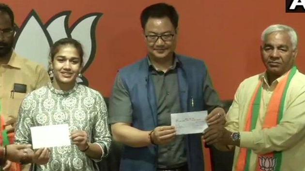 Wrestler Babita Phogat and her father Mahavir Singh Phogat join Bharatiya Janata Party in the presence of Union Minister Kiren Rijiju.(ANI Photo)