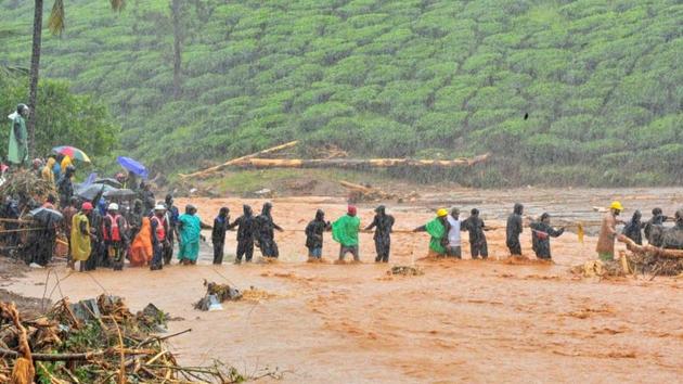 Rescuers help people to cross a flooded area after a landslide caused by torrential monsoon rains in Meppadi in Wayanad district. Over 2.5 lakh people across 14 districts were affected from heavy downpour while 32 people sustained injuries due to flood-related incidents. (REUTERS)