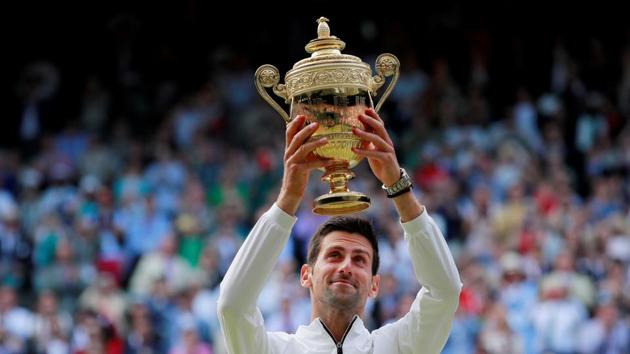 Serbia's Novak Djokovic poses with the trophy as he celebrates winning the final against Switzerland's Roger Federer.(REUTERS)