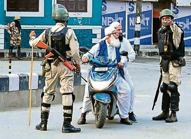 Security personnel stop Muslims for questioning during a lockdown in Srinagar on August 12, 2019.(Reuters)