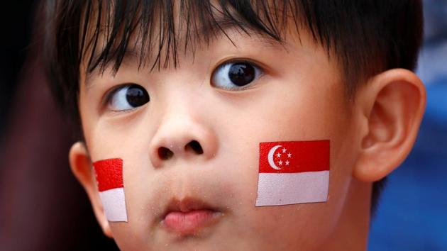 A young boy, face painted with national flag is seen during Singapore's 54th National Day Parade in Singapore. The Monetary Authority of Singapore is likely to ease policy when it reviews its stance in October, economists say. (REUTERS)