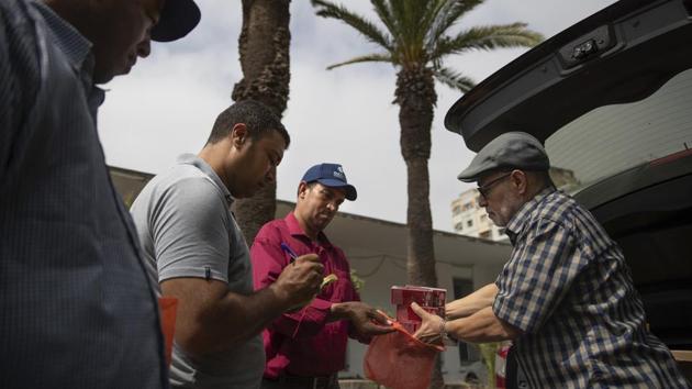 Habib El Ghazaoui (R) who runs the Association for Solidarity with Children of the Moon, distributes cream to parents of children affected by a rare disorder inside a hospital. “It hurts me that I have to see little kids suffer because of lack of awareness,” says Habib El Ghazaoui, who quit his veterinary job and made it his life’s mission to raise awareness and help children with XP after learning that his daughter Fatimazehra had the disorder. (Mosa'ab Elshamy / AP)