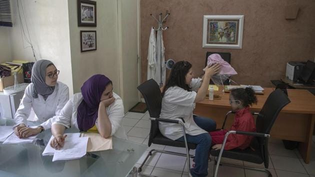 A nurse takes off a protective mask as she performs skin check-ups on 6 year-old Yasmin. The disorder is inherited, and is more common in populations where marriage between relatives is high, Kraemer said. Affected children inherit two copies of a mutated gene, one from each parent. A 2016 Moroccan government study estimates about 15% of marriages are between family members. (Mosa'ab Elshamy / AP)