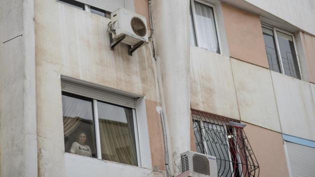 Fatimazehra El Ghazaoui, 27, a woman affected by a rare disorder stands at the window of her home. A rare genetic disorder called xeroderma pigmentosum, or XP, can make sun rays and other sources of ultraviolet light extremely damaging to the skin and eyes. This disorder is more common in North Africa than much of the world. (Mosa'ab Elshamy / AP)