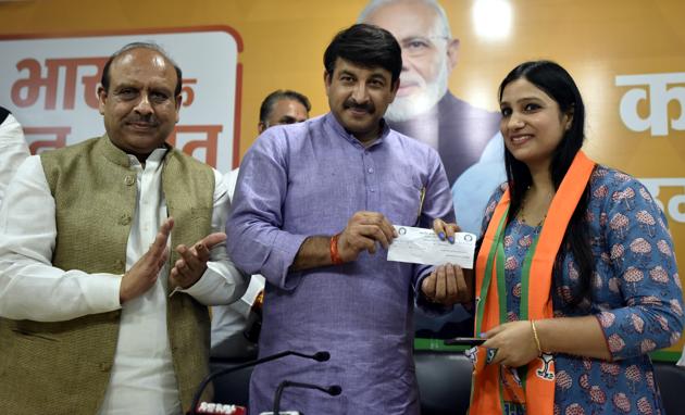 Delhi BJP President Manoj Tiwari presents a membership slip to Professor Shafali during an event where a large number of professionals joined BJP .(HT PHOTO)