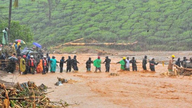 Rescuers help people cross a flooded area after a landslide caused by torrential monsoon rains in Meppadi in Wayanad district in Kerala. (Reuters file photo) Rescuers help people cross a flooded area after a landslide caused by torrential monsoon rains in Meppadi in Wayanad district in Kerala. (Reuters file photo)