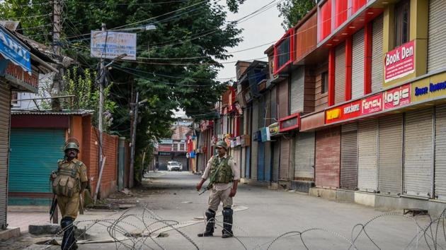 Security personnel stand guard during restrictions, in Srinagar on Monday.(PTI)