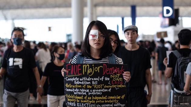 A protester holds a placard during another demonstration at Hong Kong's international airport on August 13, 2019. Some flights resumed but many others were cancelled. Hong Kong flag carrier Cathay Pacific said it had cancelled more than 200 flights into and out of the airport on Tuesday, according to its website. The airport, one of the world’s busiest, blamed demonstrators for halting flights on Monday. (Philip FONG / AFP) A protester holds a placard during another demonstration at Hong Kong's international airport on August 13, 2019. Some flights resumed but many others were cancelled. Hong Kong flag carrier Cathay Pacific said it had cancelled more than 200 flights into and out of the airport on Tuesday, according to its website. The airport, one of the world’s busiest, blamed demonstrators for halting flights on Monday. (Philip FONG / AFP)