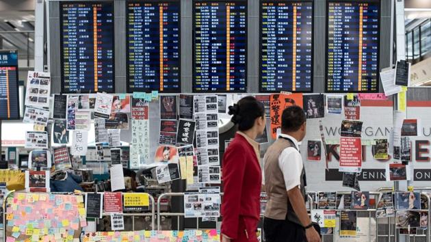 Two flight attendants walk past an electric display board covered with memos and posters at Hong Kong's international airport. UN High Commissioner for Human Rights Michelle Bachelet is “concerned by the ongoing events in the Hong Kong Special Administrative Region and the escalation of violence that has taken place in recent days,” her spokesman Rupert Colville told reporters in Geneva. (Philip FONG / AFP) Two flight attendants walk past an electric display board covered with memos and posters at Hong Kong's international airport. UN High Commissioner for Human Rights Michelle Bachelet is “concerned by the ongoing events in the Hong Kong Special Administrative Region and the escalation of violence that has taken place in recent days,” her spokesman Rupert Colville told reporters in Geneva. (Philip FONG / AFP)